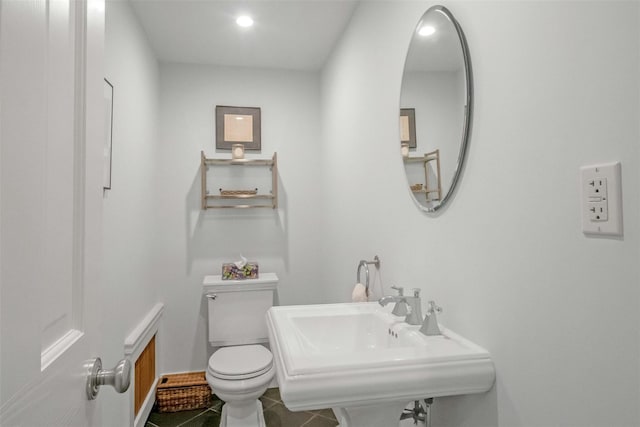 bathroom featuring toilet, tile patterned flooring, and sink