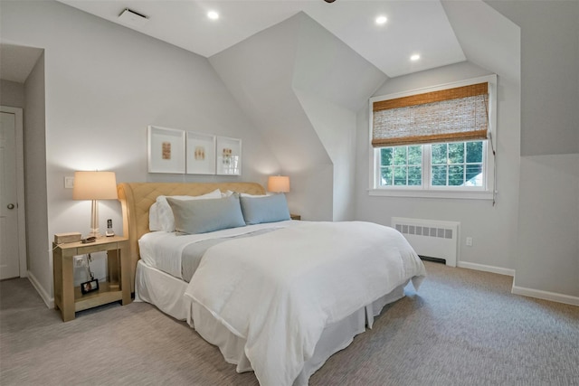 bedroom with radiator, vaulted ceiling, and light carpet