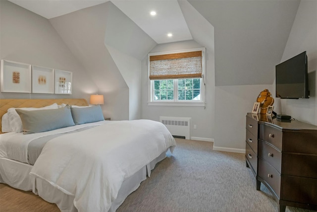 bedroom featuring radiator, vaulted ceiling, and light colored carpet