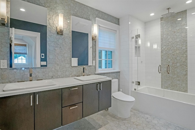 full bathroom featuring combined bath / shower with glass door, vanity, tile patterned floors, and toilet