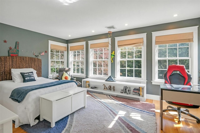 bedroom with wood-type flooring and multiple windows