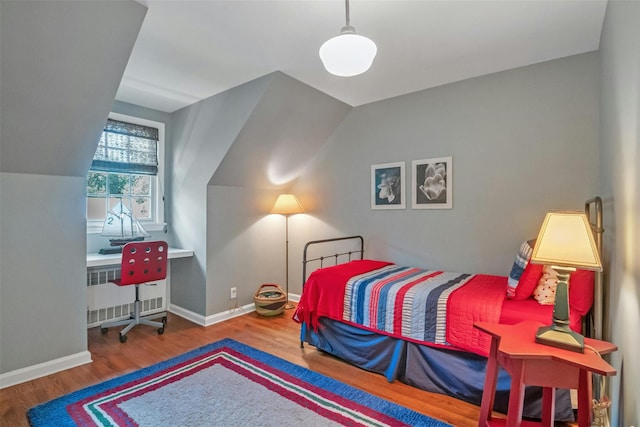 bedroom with radiator and hardwood / wood-style flooring