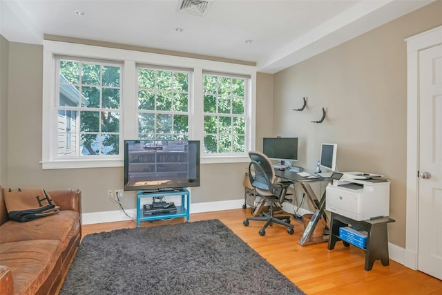 home office featuring a healthy amount of sunlight and hardwood / wood-style floors