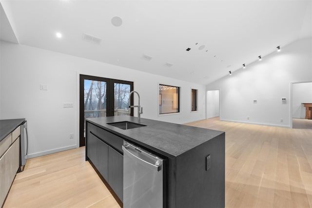 kitchen featuring lofted ceiling, sink, stainless steel dishwasher, and a center island with sink