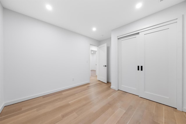 unfurnished bedroom with light hardwood / wood-style floors and a closet