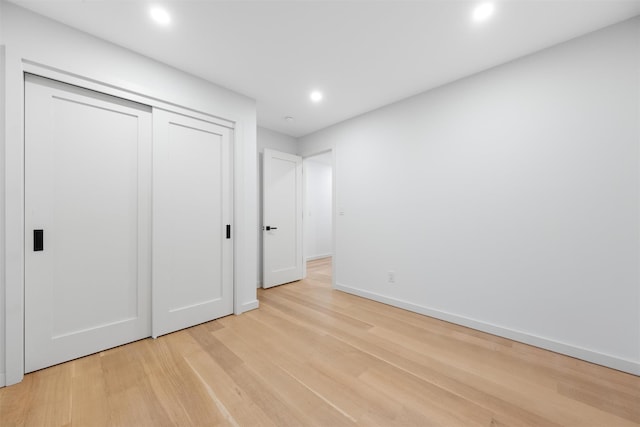 unfurnished bedroom with a closet and light hardwood / wood-style flooring