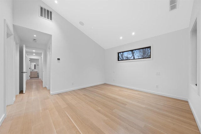 unfurnished room featuring light hardwood / wood-style flooring and high vaulted ceiling