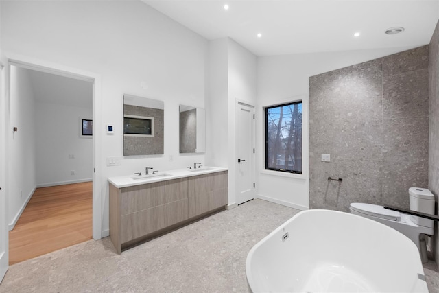 bathroom featuring toilet, high vaulted ceiling, vanity, a bath, and hardwood / wood-style floors