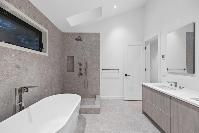 bathroom with vanity, shower with separate bathtub, a skylight, and tile walls