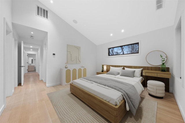 bedroom with high vaulted ceiling and light hardwood / wood-style floors