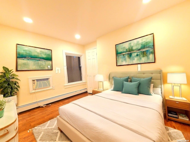 bedroom with hardwood / wood-style flooring, an AC wall unit, and a baseboard radiator