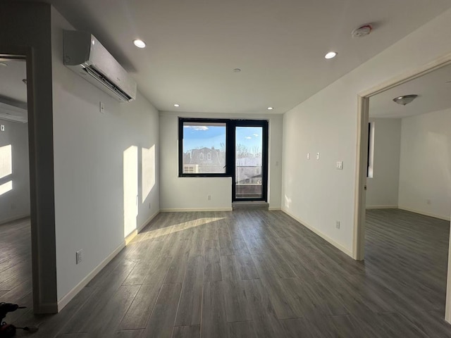 spare room with a wall unit AC and dark wood-type flooring