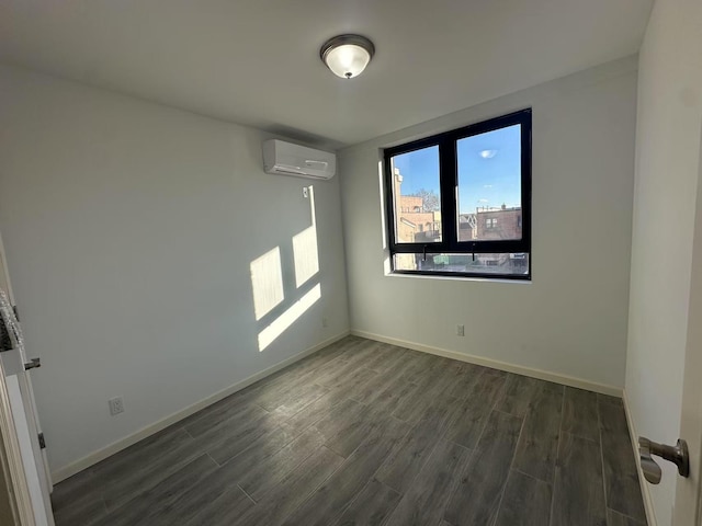 spare room with an AC wall unit and dark wood-type flooring