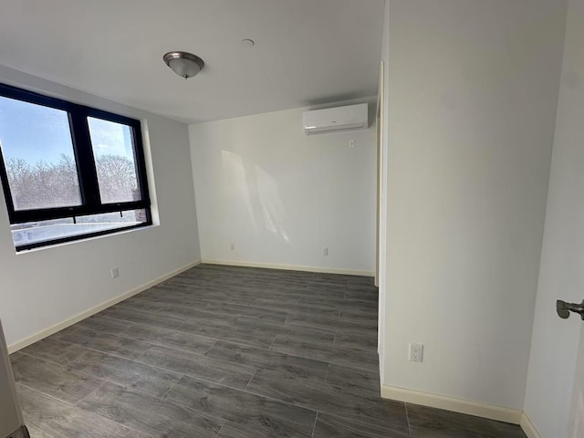 unfurnished room with dark wood-type flooring and a wall unit AC