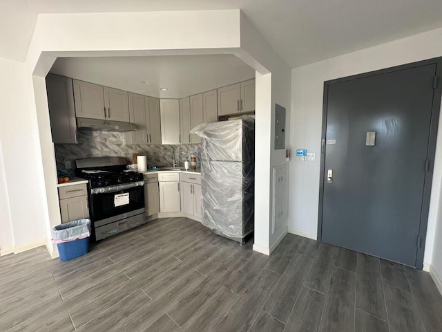 kitchen with stainless steel gas range oven, backsplash, electric panel, refrigerator, and gray cabinets