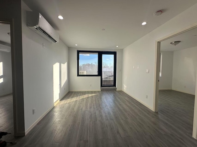 empty room featuring a wall unit AC, dark wood-type flooring, and a wall of windows