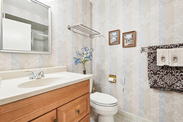 bathroom with tile patterned flooring, vanity, and toilet