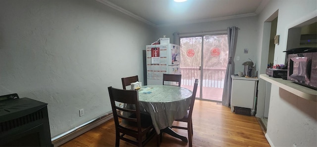 dining area featuring light wood-type flooring, crown molding, and water heater