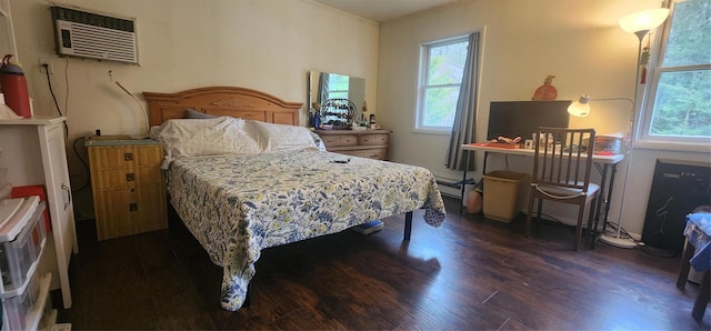 bedroom with dark hardwood / wood-style floors, baseboard heating, and a wall unit AC