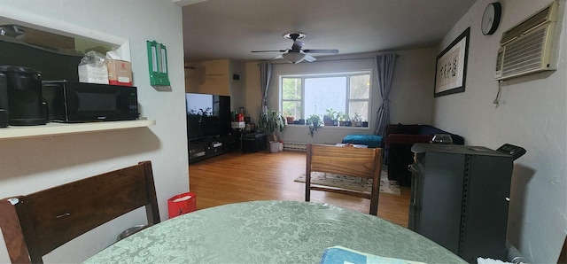 dining space featuring an AC wall unit, ceiling fan, and hardwood / wood-style flooring