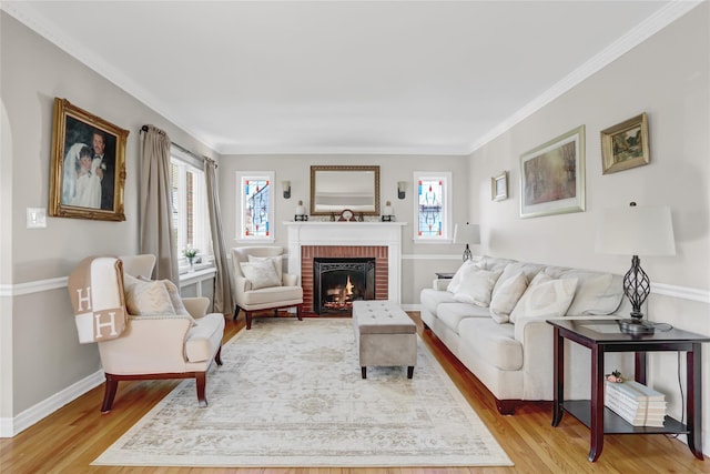 living room featuring a fireplace, light hardwood / wood-style flooring, and crown molding