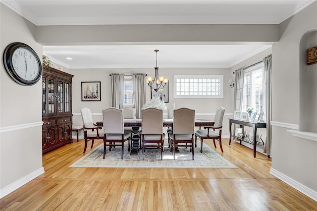 dining space featuring plenty of natural light, ornamental molding, and hardwood / wood-style flooring