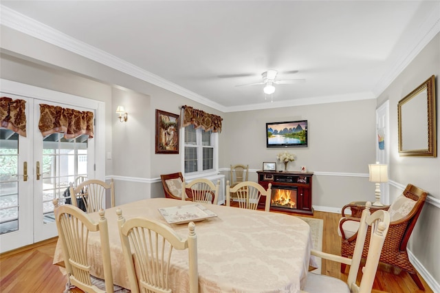 dining space featuring ceiling fan, french doors, ornamental molding, and light hardwood / wood-style flooring