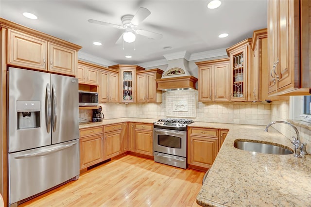 kitchen featuring ceiling fan, sink, light hardwood / wood-style floors, custom range hood, and appliances with stainless steel finishes