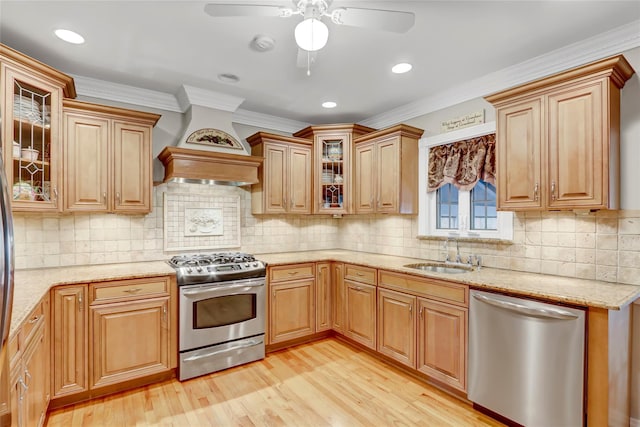 kitchen featuring sink, ceiling fan, ornamental molding, light hardwood / wood-style floors, and stainless steel appliances