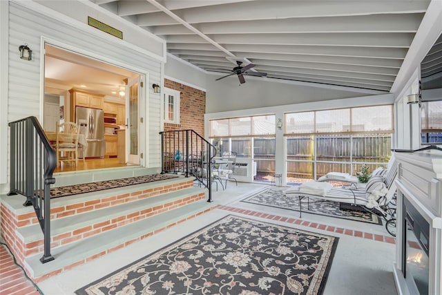 sunroom with ceiling fan and vaulted ceiling