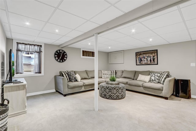 carpeted living room with a paneled ceiling