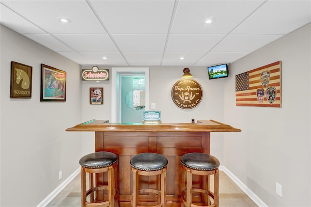 bar with a drop ceiling and light colored carpet