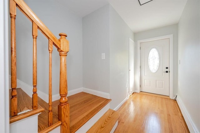 entryway with light wood finished floors, stairs, and baseboards