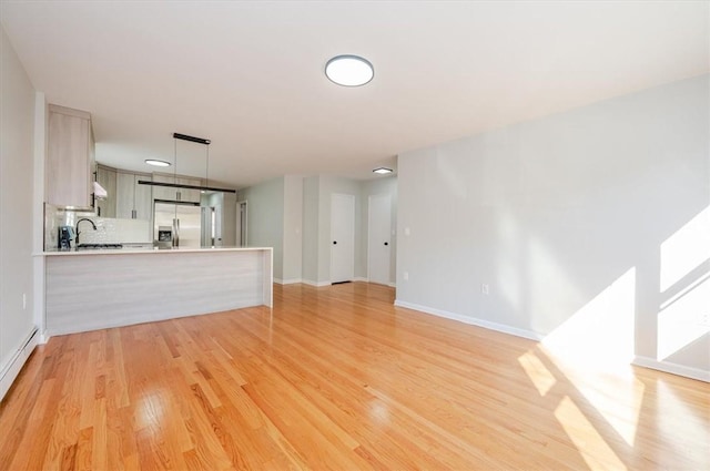 unfurnished living room featuring light wood-type flooring and sink