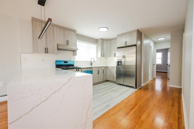 kitchen featuring stainless steel fridge with ice dispenser, gas range, light hardwood / wood-style flooring, and sink