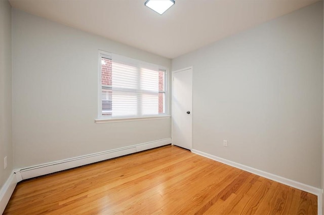 spare room with light hardwood / wood-style floors and a baseboard heating unit