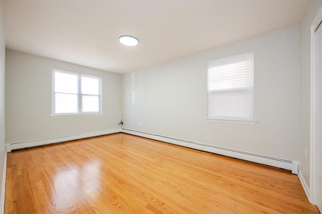 unfurnished room featuring light wood-type flooring and a baseboard radiator