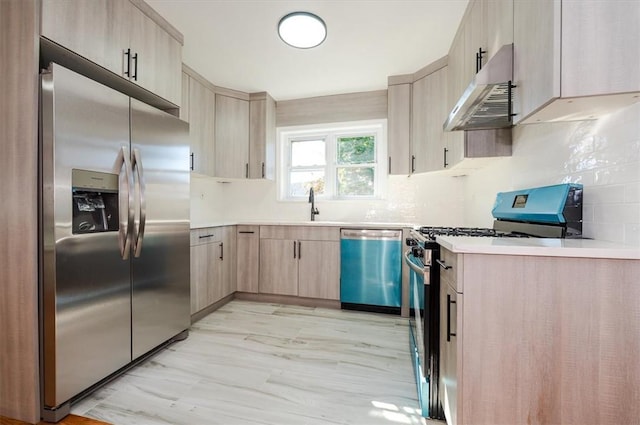 kitchen featuring sink, decorative backsplash, range hood, light brown cabinetry, and appliances with stainless steel finishes