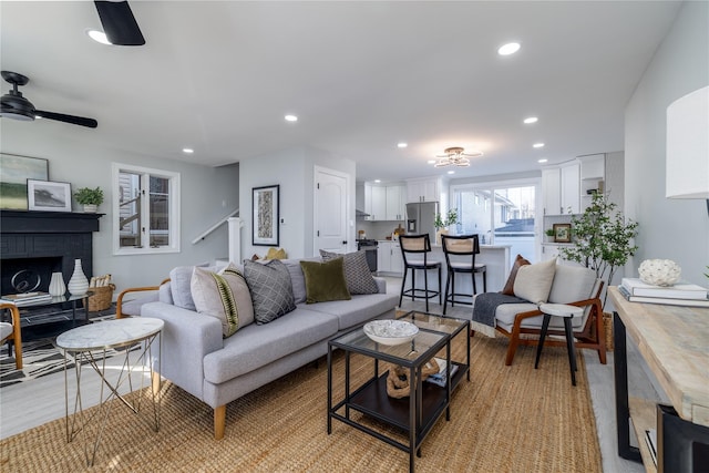 living room featuring a fireplace and ceiling fan