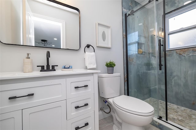 bathroom with tile patterned floors, vanity, toilet, and an enclosed shower