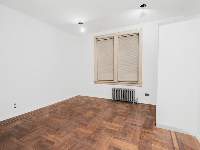 spare room with radiator and parquet flooring