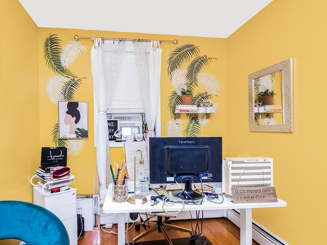 office space with wood-type flooring and a baseboard heating unit