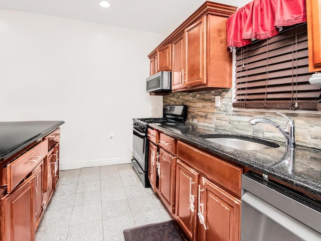 kitchen with dark stone countertops, sink, appliances with stainless steel finishes, and tasteful backsplash