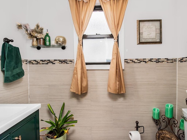 bathroom with vanity and tile walls