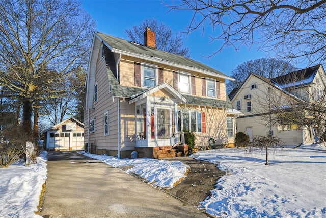 colonial-style house featuring a garage and an outdoor structure