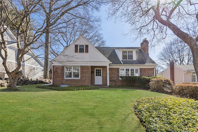 view of front of house with brick siding, a chimney, and a front lawn