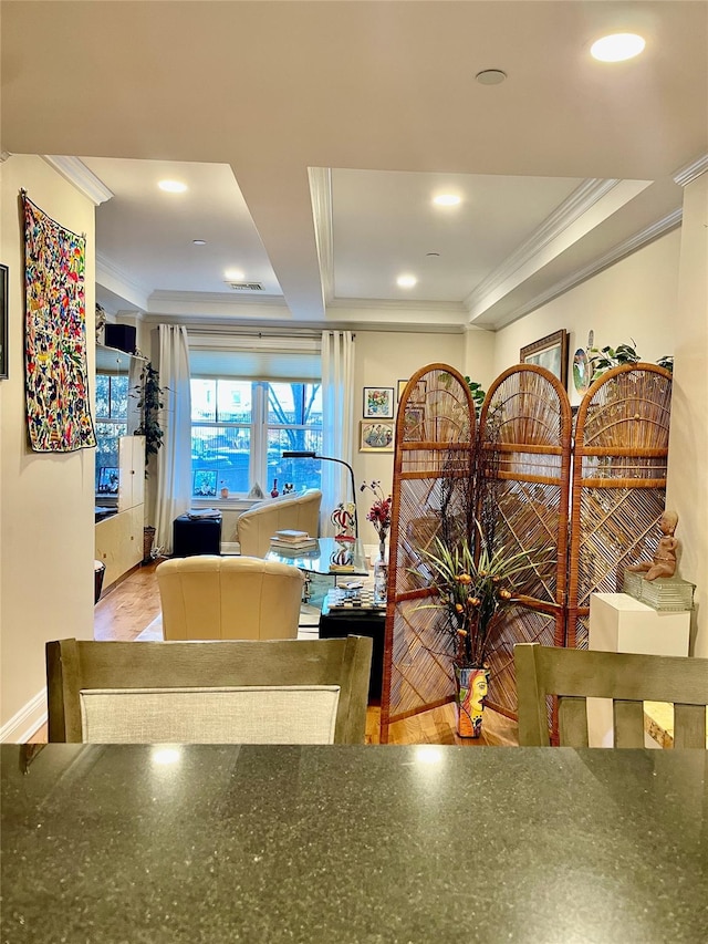 interior space with hardwood / wood-style flooring, a tray ceiling, and crown molding