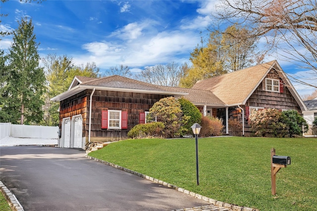 view of front of house with a garage and a front lawn