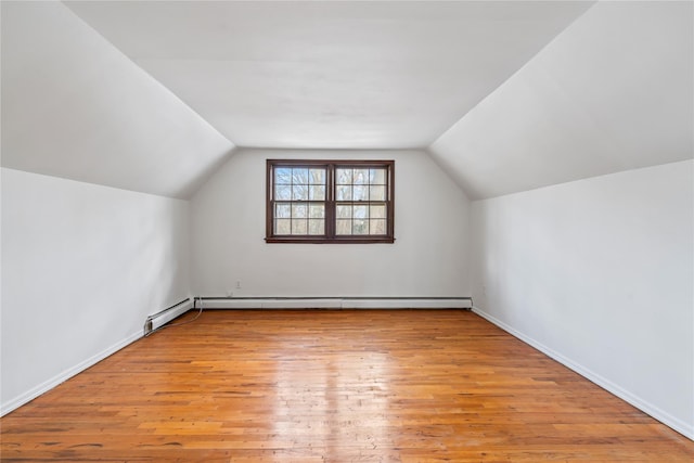 bonus room featuring vaulted ceiling, a baseboard heating unit, and light hardwood / wood-style floors