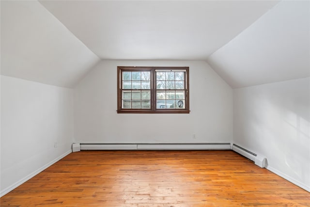 additional living space featuring lofted ceiling, light wood-type flooring, and baseboard heating